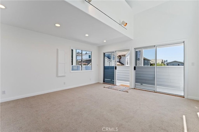 unfurnished living room featuring light carpet and plenty of natural light