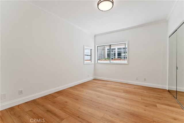 unfurnished bedroom featuring light hardwood / wood-style floors, a closet, and crown molding