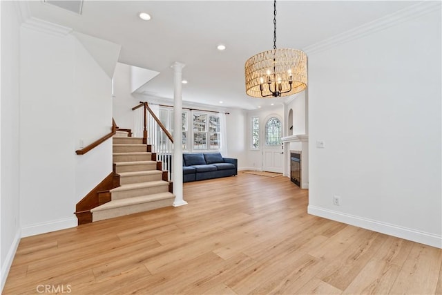 foyer entrance featuring ornamental molding, a chandelier, and light wood-type flooring