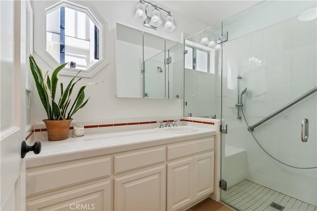 bathroom featuring tile patterned floors, vanity, and a shower with shower door