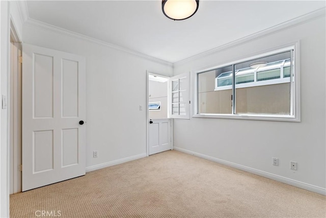 spare room featuring light carpet, plenty of natural light, and crown molding