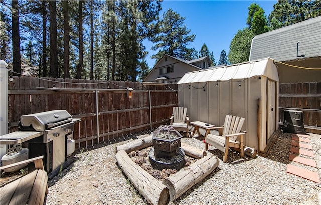 view of patio with grilling area, an outdoor fire pit, and a shed