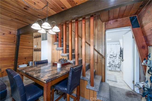 dining space with an inviting chandelier, wood walls, and wooden ceiling