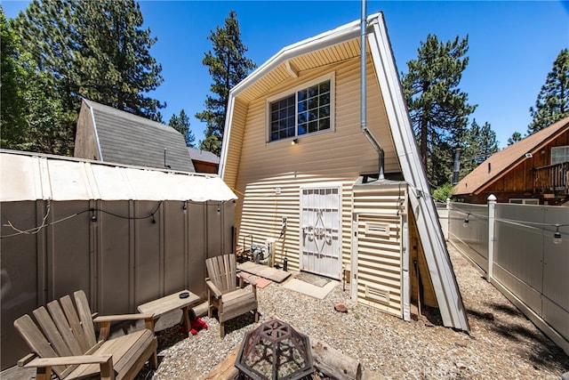 rear view of property with a storage unit