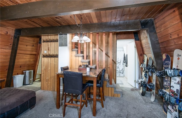 dining area featuring carpet flooring, wooden walls, beam ceiling, and wooden ceiling