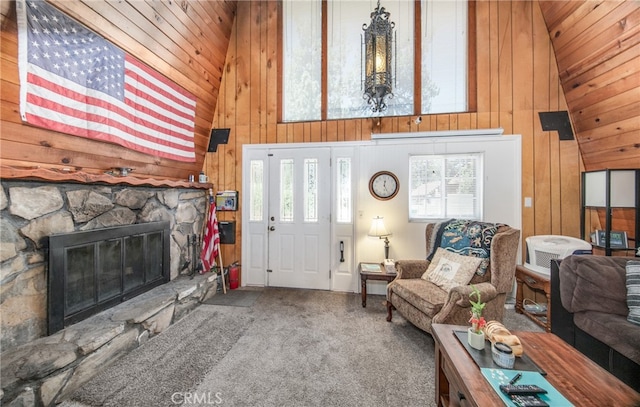 carpeted living room featuring a fireplace, wood walls, wood ceiling, and high vaulted ceiling