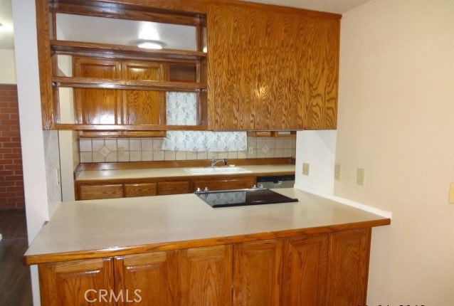 kitchen featuring black electric cooktop, dishwasher, backsplash, and sink