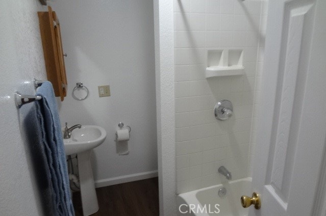 bathroom featuring wood-type flooring and shower / bathing tub combination