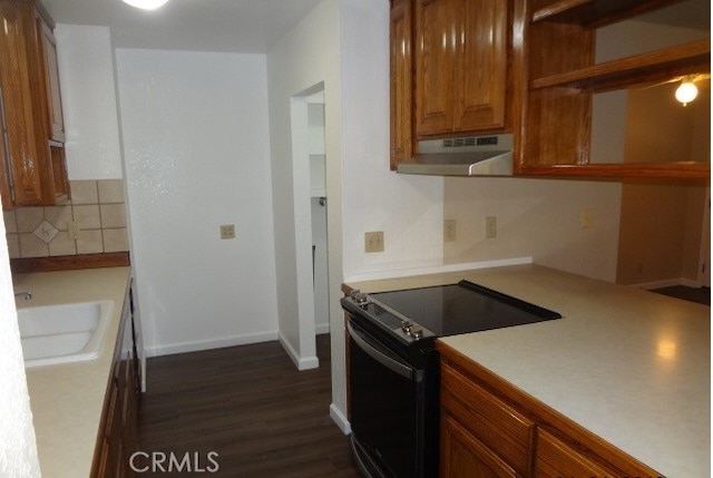 kitchen with black electric range, dark hardwood / wood-style floors, sink, and tasteful backsplash