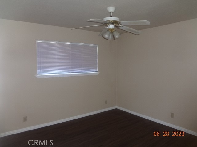 empty room featuring ceiling fan and dark hardwood / wood-style flooring