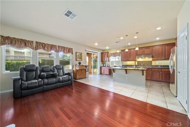 living room featuring sink and light hardwood / wood-style flooring