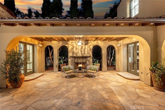 patio terrace at dusk with ceiling fan and french doors