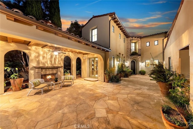 exterior space with ceiling fan, french doors, and an outdoor fireplace