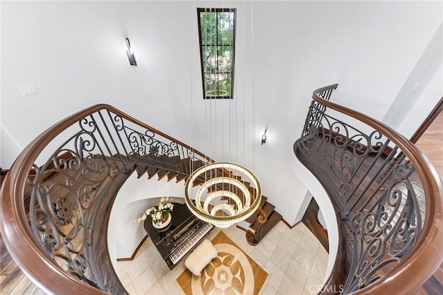 staircase featuring hardwood / wood-style floors and a notable chandelier