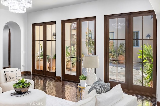 doorway with a chandelier, dark wood-type flooring, and french doors