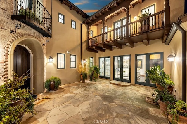 exterior space featuring a balcony, a patio, and french doors