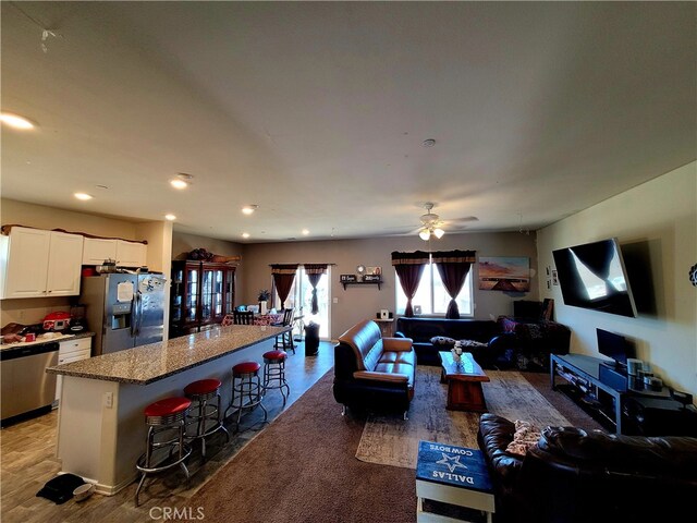 living room with ceiling fan and hardwood / wood-style flooring