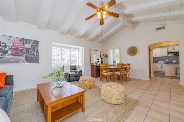 living room featuring beamed ceiling, ceiling fan, light tile patterned floors, and high vaulted ceiling