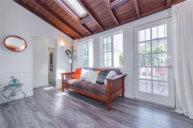 living room featuring vaulted ceiling with skylight, wood ceiling, and wood-type flooring