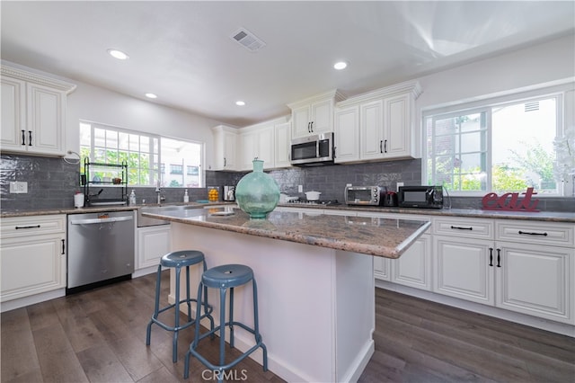 kitchen with white cabinets, a kitchen island, and stainless steel appliances