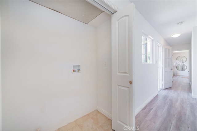 laundry room featuring washer hookup and light hardwood / wood-style flooring