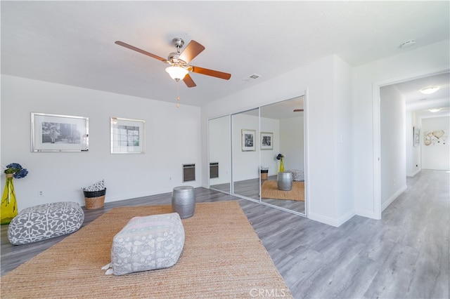 sitting room with ceiling fan and hardwood / wood-style floors