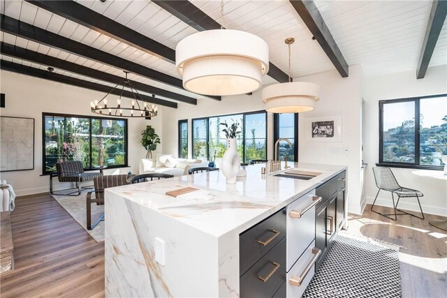 kitchen featuring pendant lighting, a center island with sink, and plenty of natural light