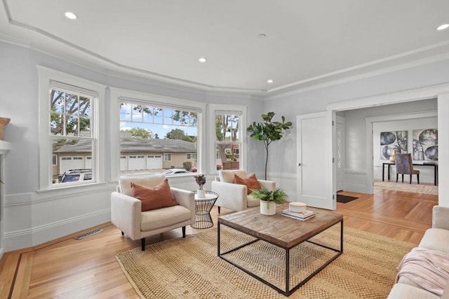 living room with crown molding and light hardwood / wood-style flooring