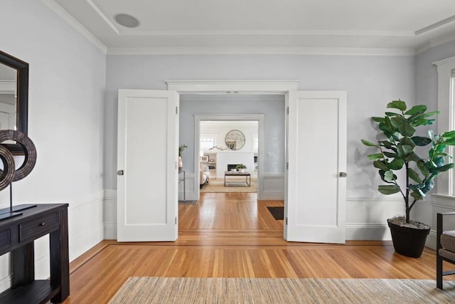 hall featuring crown molding and light hardwood / wood-style floors