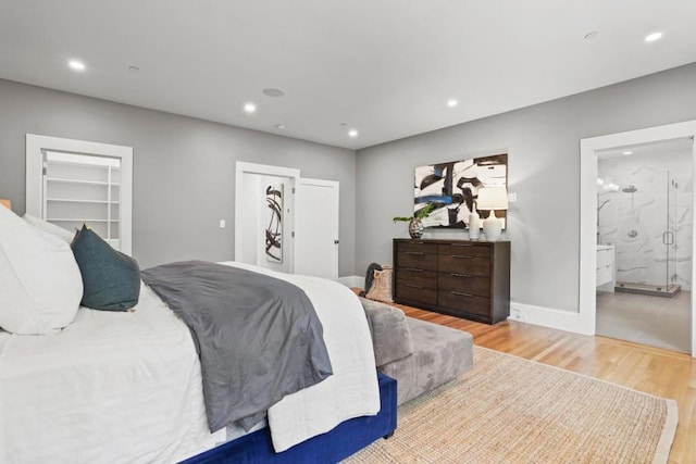 bedroom featuring connected bathroom and light wood-type flooring