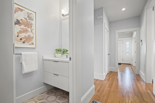 hallway featuring sink and light wood-type flooring