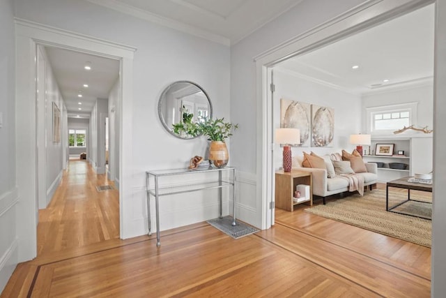 hallway with hardwood / wood-style floors and ornamental molding