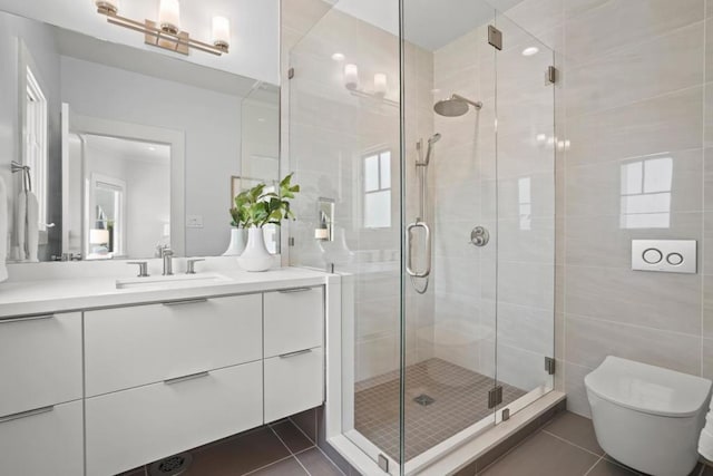 bathroom featuring vanity, tile patterned flooring, a shower with shower door, and toilet