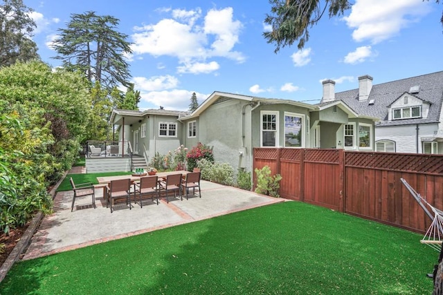 back of property featuring a patio and a yard