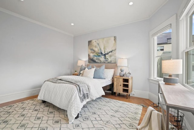 bedroom featuring ornamental molding and light hardwood / wood-style floors