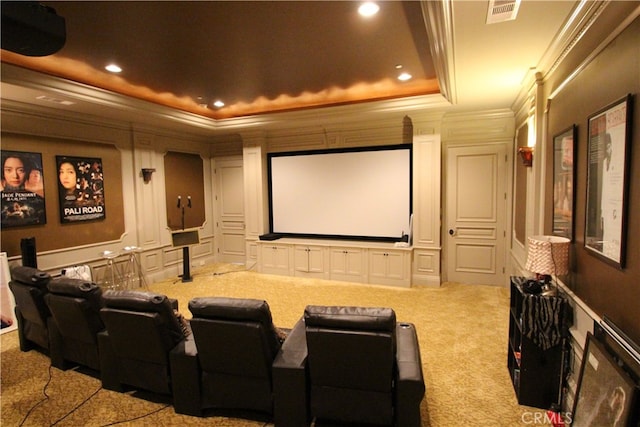 carpeted home theater room featuring a tray ceiling and crown molding