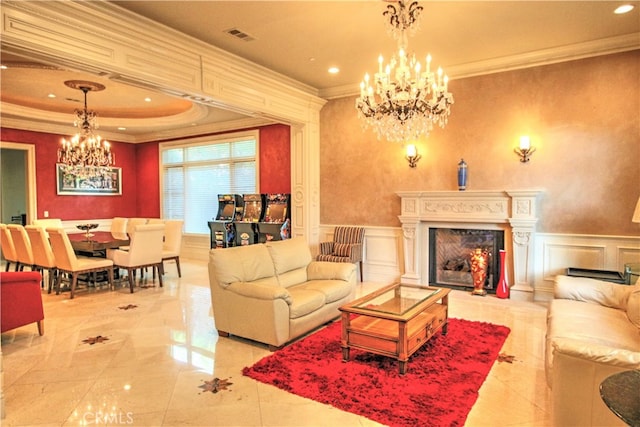 living room with an inviting chandelier, a high end fireplace, and ornamental molding