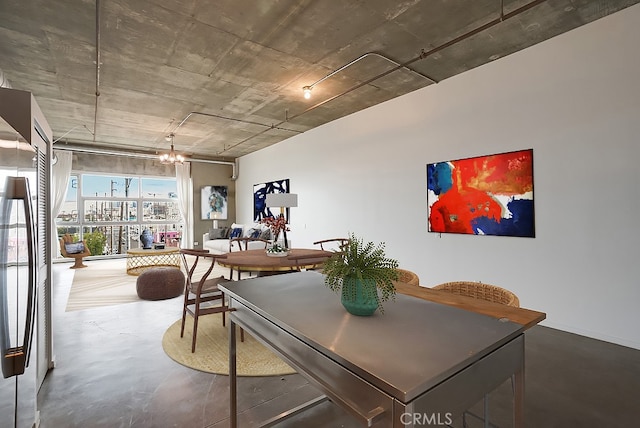 dining space with a notable chandelier, expansive windows, and concrete floors