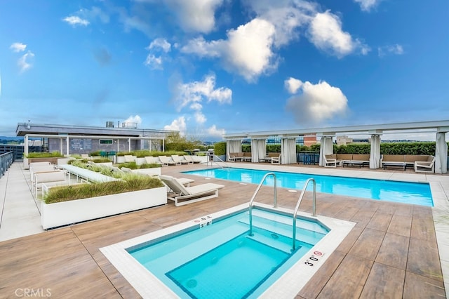 view of swimming pool featuring a patio and a hot tub