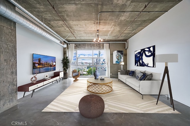 living room featuring concrete floors and an inviting chandelier