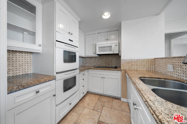 kitchen with decorative backsplash, white cabinetry, sink, and white appliances