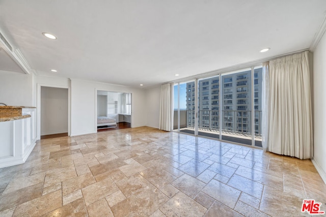 unfurnished living room with expansive windows and ornamental molding