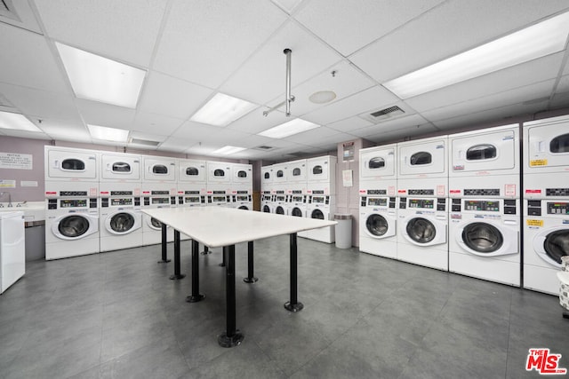 washroom with stacked washer / dryer, washer and clothes dryer, and sink