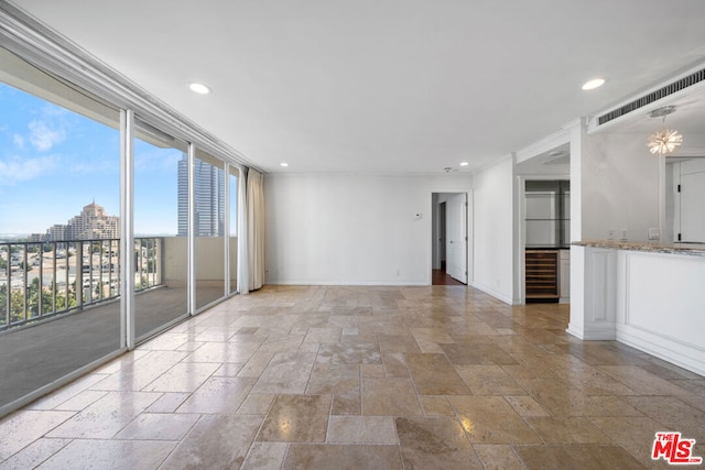 empty room featuring a notable chandelier and wine cooler