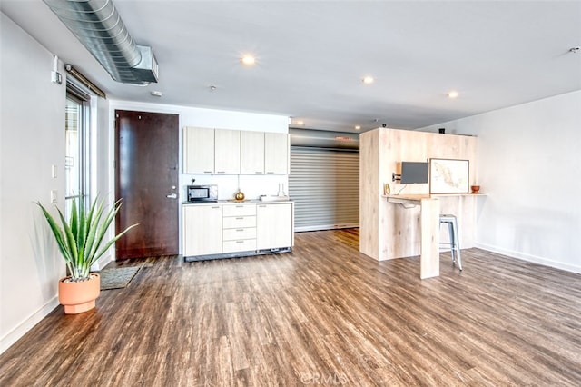 kitchen featuring a breakfast bar and dark hardwood / wood-style flooring