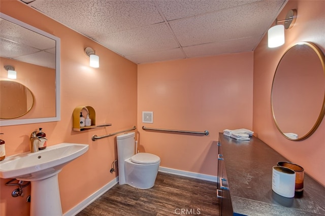 bathroom featuring toilet, a drop ceiling, and hardwood / wood-style flooring