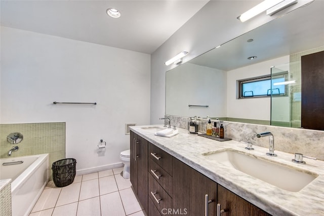 bathroom with tile patterned flooring, vanity, toilet, and a washtub