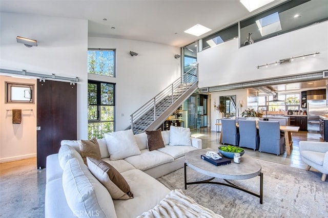 living room with a high ceiling and a barn door