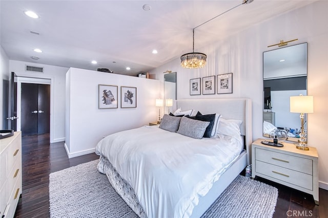 bedroom featuring dark hardwood / wood-style flooring and a notable chandelier