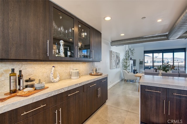 bar featuring dark brown cabinets and decorative backsplash